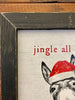 A black and white sign with a donkey wearing a red santa hat staring at you. The words are in red around the donkey say:  Jingle all the Way - no one likes a Half Assed Jingler.  This is a close up of the frame.