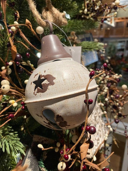  A white  aged metal round bell. It hangs from a jute hanger. There are star cutout around the top half of the bell. It has a ringer so will "jingle". 