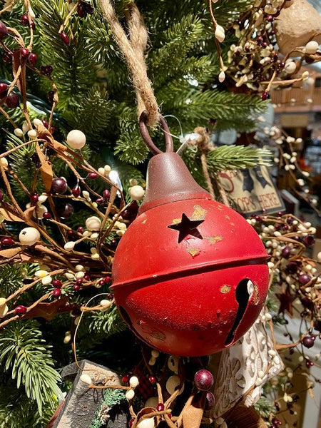  A red aged metal round bell. It hangs from a jute hanger. There are star cutout around the top half of the bell. It has a ringer so will "jingle". 