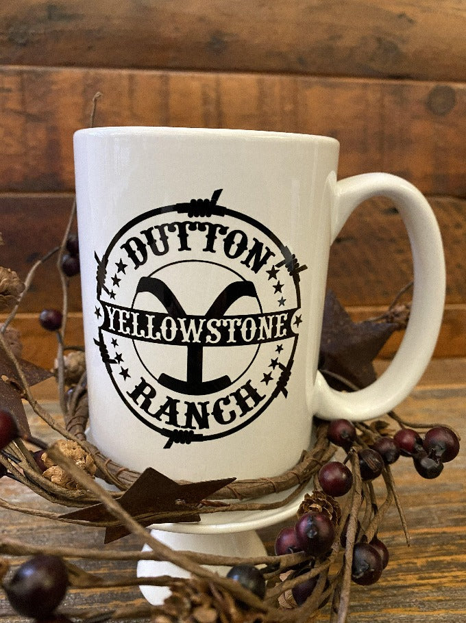 A white ceramic mug of the Dutton Ranch-Yellowstone Brand Mug. It is printed on both sides.
