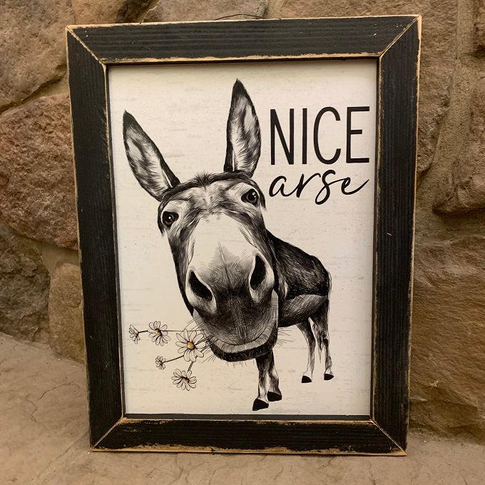 This fun picture has an donkey with daisies in his mouth and the words, "Nice Arse".  It is in a black wooden distrssed frame and measures 13" x 17". There is a vintage wire attached to the frame for easy hanging. 