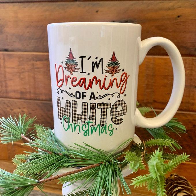 A white ceramic mug, printed on both sides that says in a colourful font - I'm Dreaming of a White Christmas.