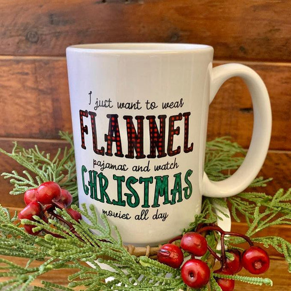 This is a white ceramic mug that reads I just want to wear flannel pajamas and watch christmas movies all day.