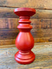 Medium sized red wooden candlestick.