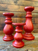 Three different sizes of the red wooden candlesticks - small, medium and large. Solid bright red in colour, turned wood candlesticks.