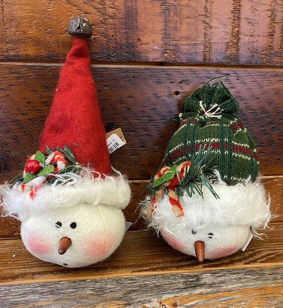 Two stuffed snowman ornaments with a tall red toque with a tiny jingle bell and one with a plaid green toque. Each one is accented with candy canes and greenery. 