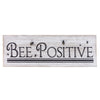 A whitewashed wooden block sign that will sit on a shelf. It says Bee Positive and has a small painted honeybees.