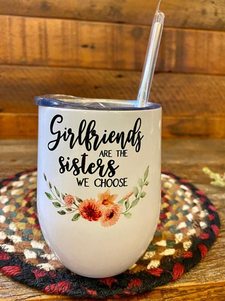 A white stainless steel wine tumbler with metal straw that says  Girlfriends are the sisters we choose. 