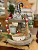 The Candy Cane Garland is a string of red, white and white stripes on red beads with jute tassels at each end. It is shown here in a centerpiece tray.