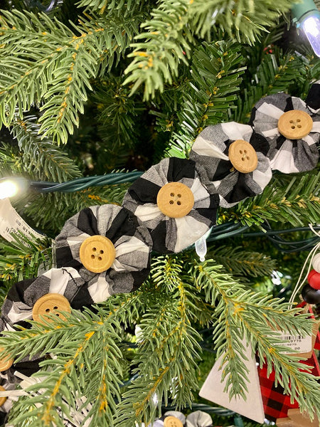 The fabric Yoyo garland is a pretty farmhouse garland. Black and white fabric circles are drawn together to look like flowers and a button is sewn onto each flower of this 6 foot long garland.
