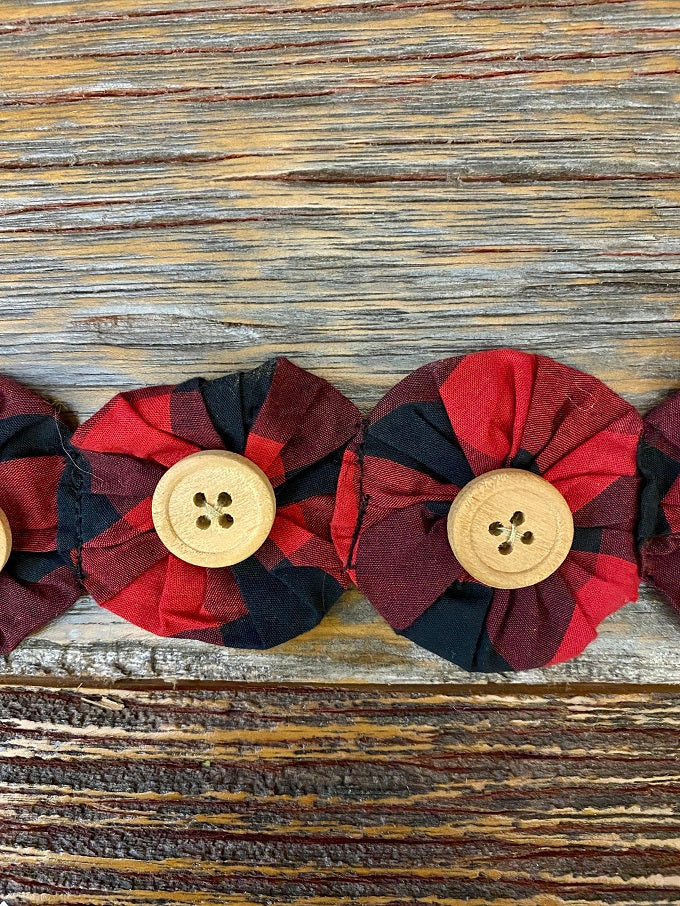 The fabric Yoyo garland is a pretty farmhouse garland. Red and Black fabric circles are drawn together to look like flowers and a button is sewn onto each flower of this 6 foot long garland.