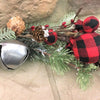 A  close up of what makes up the beautiful picks, wreaths and garland in the country holiday buffalo plaid collection:  snowy Christmas greens, silver jingle bells and round red and black check fabric coloured balls, pine cones and jute rope.