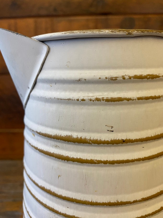 A close up of the White and Yellow Trim Metal Pitcher.