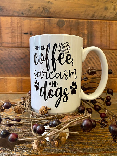 A white ceramic coffee mug that says, I run of coffee, sarcasm and dogs.
