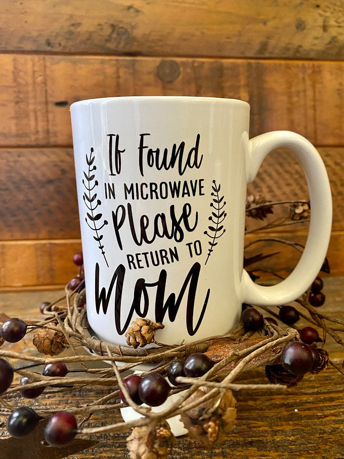 A white ceramic coffee mug that says If Found in Microwave, please return to Mom.