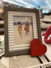 A gray and corrugated white wooden frame with a red Distressed Heart.