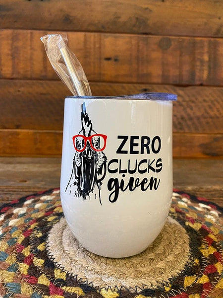 A white stainless steel wine tumbler with metal straw. The tumbler has a picture of chicken and beside it says Zero Clucks Given.